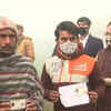 Union minister Mukhtar Abbas Naqvi stands in a queue at a polling booth in Rampur to cast his vote