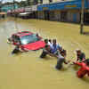 Rescuers try to pull out a car from flooded Rainbow Drive Layout after heavy monsoon rains at Sarjapur, in Bengaluru. Photo: PTI