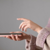Holding phone with one hand and using index finger of another hand