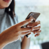 Holding phone with both hands and using both thumbs