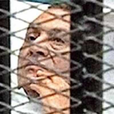Bedridden, caged, Mubarak on trial