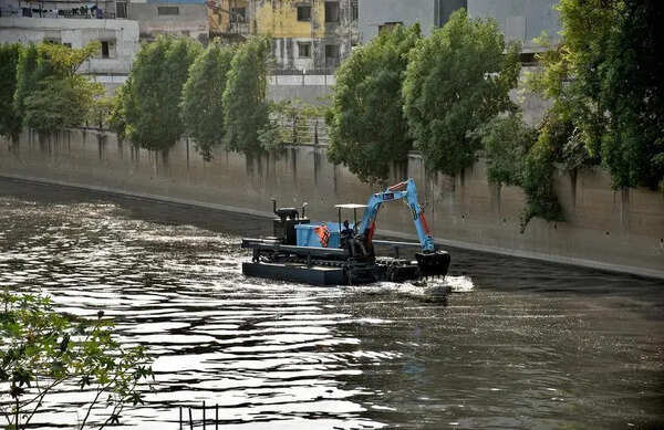 Floating hydraulic excavator to clean creeks