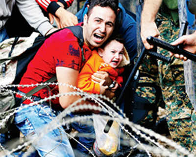 Man desperately holds onto son as Macedonia cops clash with migrants