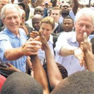 Bush wipes hand on Clinton's shirt after handshake with Haitian man