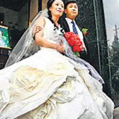 Bride walks down aisle in paper gown