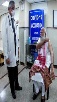 PM Modi gets his first vaccine dose as AIIMS Director <i class="tbold">dr randeep guleria</i> looks on.