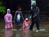 Family walks on the waterlogged streets in Mumbai