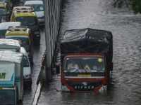 <i class="tbold">truck</i>s carrying heavy loads stuck in flood