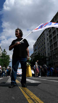 A protester raises a flag of the Greek communist party during the 24-hour labour protest
