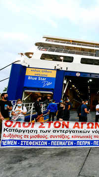 Protesters block the entrance of a passenger ferry during a 24-hour labour strike