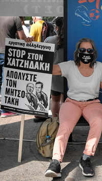 A woman holds a placard reading in Greek 'stop to Hatzidakis (minister of labour) law - fire Mitsotakis'
