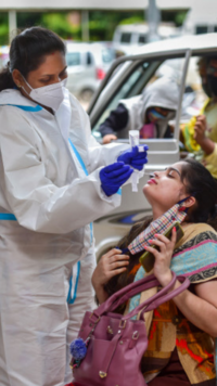 A health worker collects swab sample of a passenger as she returns.