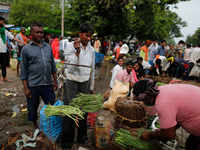 Farmers stand with wares in their hand at a wholesale market
