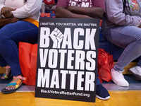 People sit next to Black voters matter board on the launch of freedom ride