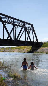 Young people try to beat the heat in an irrigation canal in Chestermere, Alta.