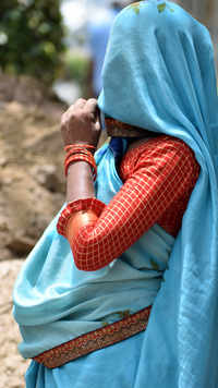 A woman covers her head and face with her saree as the heatwave continues.