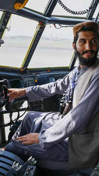 Taliban fighter sits in the cockpit of an <i class="tbold">afghan air force</i> aircraft.