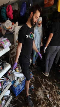 People remove flood-damaged merchandise from a store that was flooded.