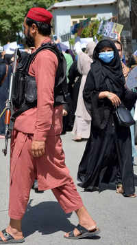 Taliban fighters keep vigil as Afghan women take part in an anti-Pakistan demonstration