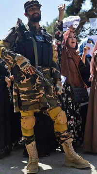 Afghan women shout slogans next to a Taliban fighter during an anti-Pakistan demonstration