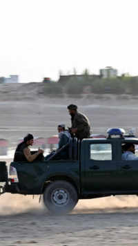 Taliban fighters ride on a vehicle near the <i class="tbold">lake area</i>
