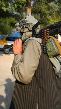 A Taliban fighter walks with his rifle at the <i class="tbold">lake area</i>
