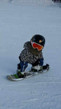 Wang Yuji sliding down a slope on her snowboard.