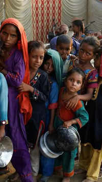 Flood victims gather to receive food in <i class="tbold">a camp</i>, following monsoon rains in Sehwan, Pakistan