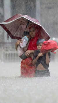 People wade through water during flood amidst heavy rains in <i class="tbold">northeastern</i> Bangladesh in June