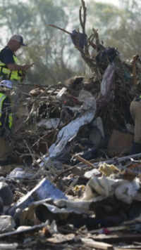 ​Emergency rescuers climb through a tornado <i class="tbold">demolish</i>ed mobile home park