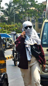 A woman cover her head and face with a scarf to protect from the sun in Andheri.
