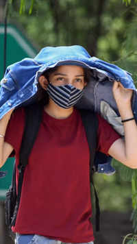 A girl covers her head with a jacket to protect herself from heat in Delhi.