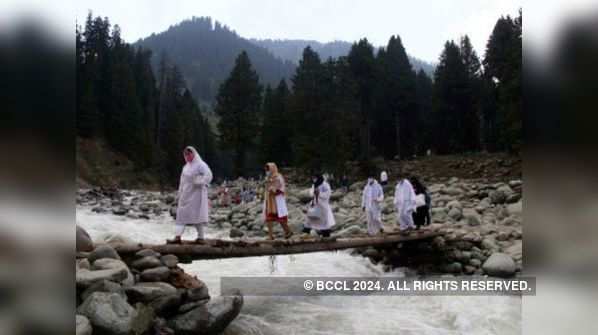 Medical workers cross wooden bridge to vaccinate people