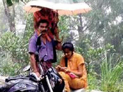 Karnataka girl studies by roadside, dad protects her from rain