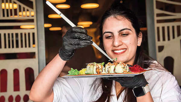 A participant adds some microgreens on her sushi
