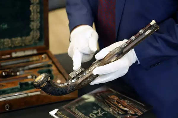 A staff member shows a detail of one of the two pistols, which belonged to Emperor Napoleon I, during the preview before their auction, in Paris on June 18, 2024.