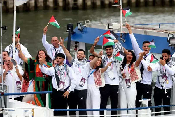 Athletes of Team Palestine wave flags on the athletes' parade team boat along the River Seine during the opening ceremony of the Olympic Games Paris 2024.