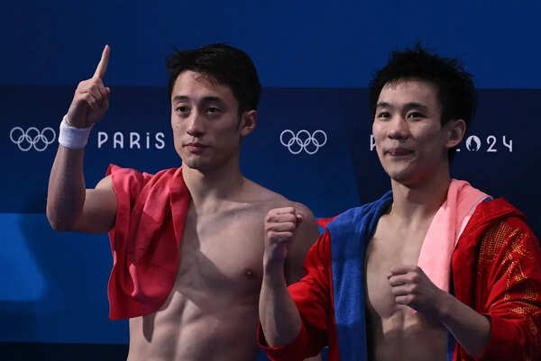 Gold medallists China's Lian Junjie and Yang Hao celebrate after the men's synchronised 10m platform diving final at the Paris 2024 Olympic Games at the Aquatics Centre in Saint-Denis, north of Paris, on July 29, 2024.