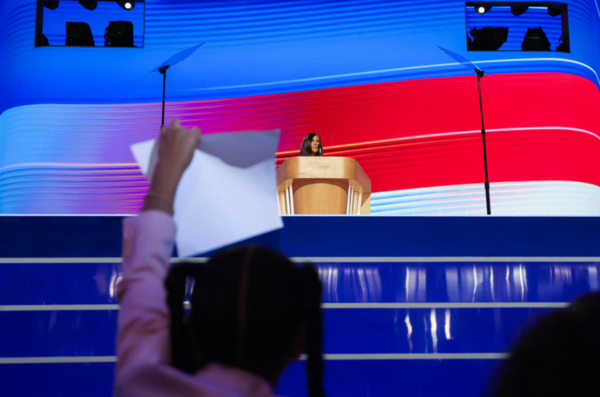 Maya Harris, sister of Democratic presidential nominee and U.S. Vice President Kamala Harris, speaks as one of Kamala's great-nieces holds a sign on Day 4 of the Democratic National Convention (DNC) at the United Center in Chicago.