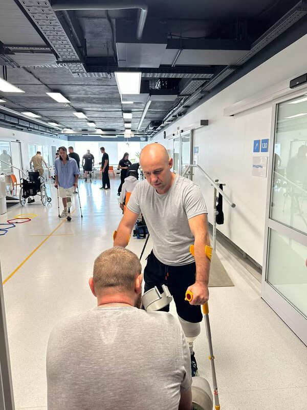 Clinicians fitting the Zeus device to an Ukranian soldier at the Superhumans center in lviv