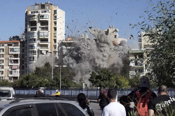 People watch a building collapse