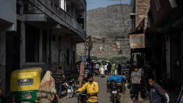 A landfill more than 200 feet tall towers over a neighborhood in Delhi, India.