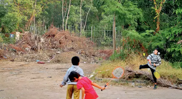 Kids playing beside the trash