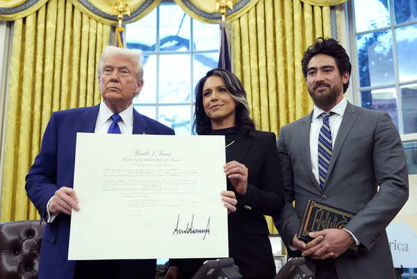 President Donald Trump stands with Tulsi Gabbard and her husband Abraham William...