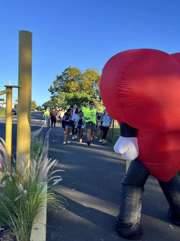 Students are greeted by the Walking School Bus’ Heart Mascot when arriving to school. (Photo Courtesy: Partners in Development Foundation)