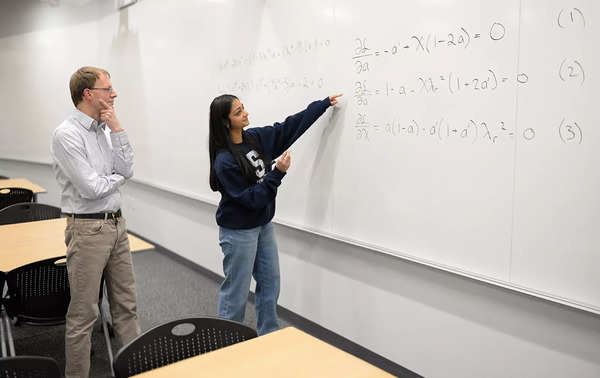 Divya Tyagi, a Penn State engineering graduate student, shows her work on a century-old math problem to Sven Schmitz, a College of Engineering faculty member and Tyagi's adviser. (Credit: psu.edu)