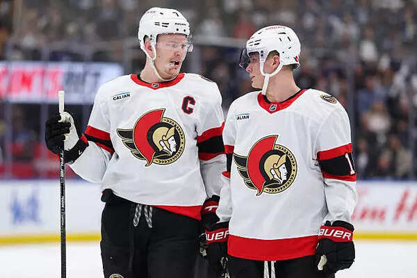 Brady Tkachuk #7 talks with Tim Stützle #18 of the Ottawa Senators during the first period of Game
