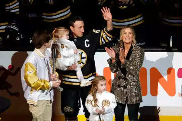 Boston Bruins left wing Brad Marchand is honored for his 1,000th career game, alongside his wife Katrina and their family