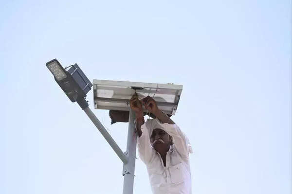 A villager disconnects solar panels from the street lights in Golap Nesda A villager disconnects solar panels from the street lights in Golap Nesda