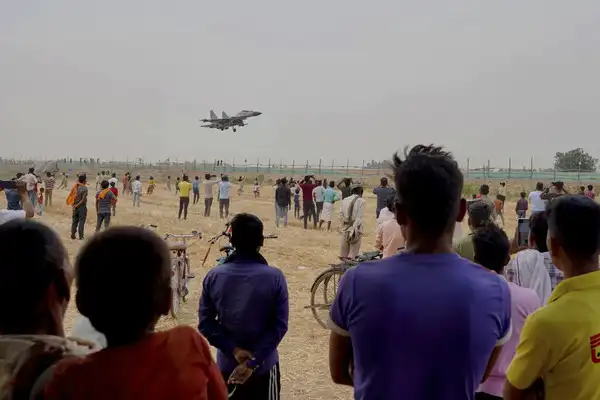 Villagers watch as an Indian Air Force fighter jet performs touch and go landings as part of a preparedness exercise to use highways as landing strips for emergencies India Air Force
